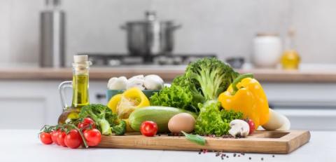 a variety of vegetables on a chopping board, in a kitchen