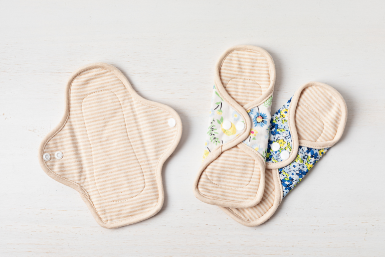 Three reusable period pads laid on white surface.