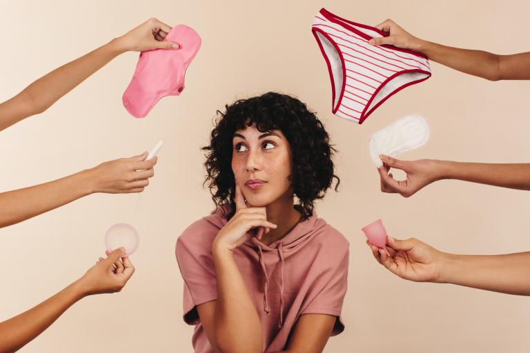 Person surrounded by various period products 