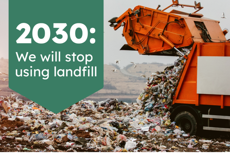 Refuse vehicle tipping load into landfill. 