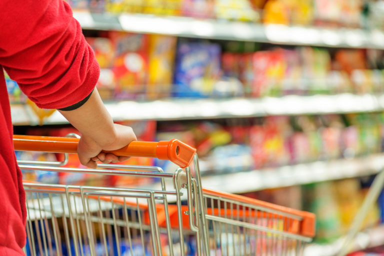 A trolley pictured in front of an aisle of food.