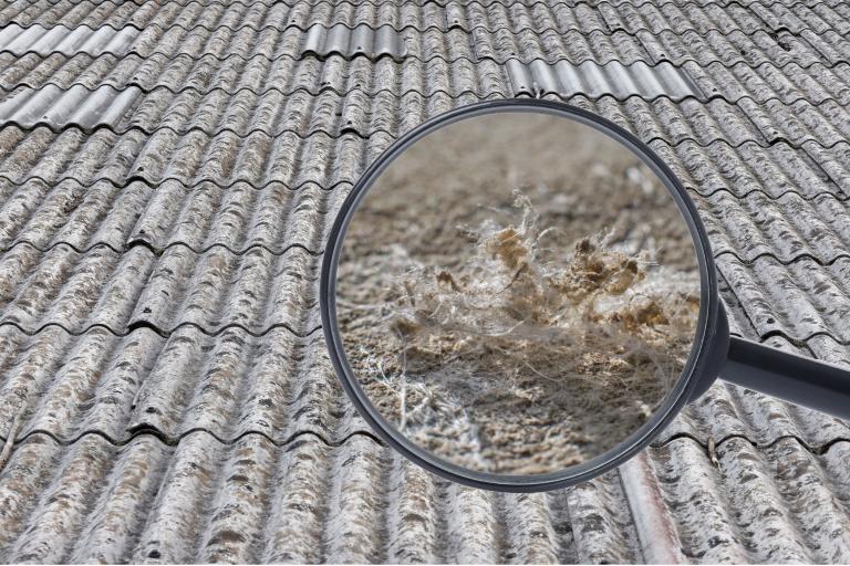 Roof tiles with a magnifying glass showing a close-up image of asbestos fibres