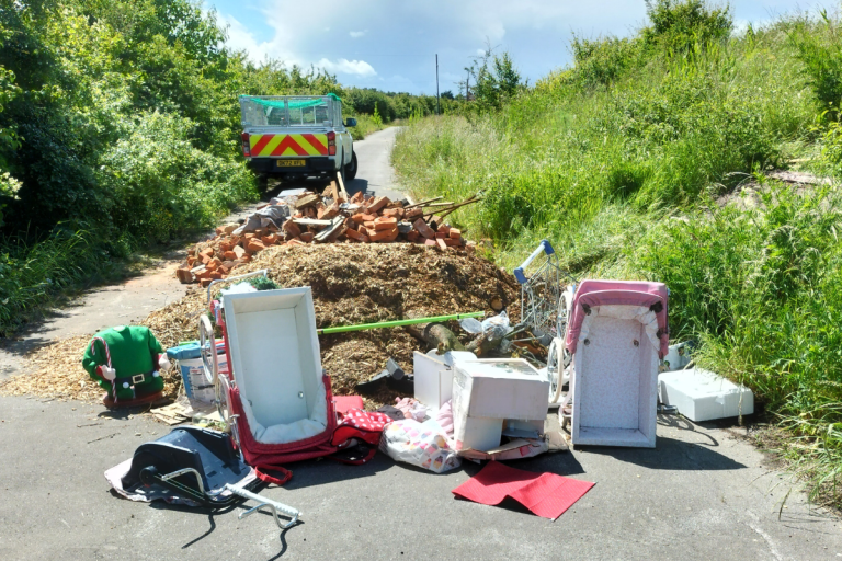 A lorry load of waste fly-tipped in the middle of a country lane.