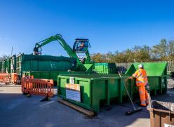 A crane and containers at a recycling centre.