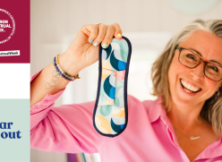 A woman holding a reusable period pad to camera. The Women’s Environmental Network Environmenstrual Week logo is in the top left corner. The Wear Em Out logo is in the bottom left corner.