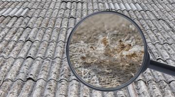 Roof tiles with a magnifying glass showing a close-up image of asbestos fibres.