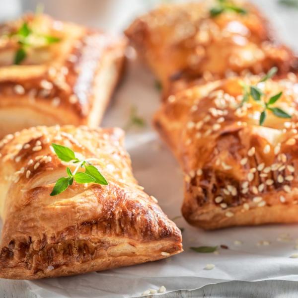 Apple, cheddar and walnut sausage rolls on a plate.